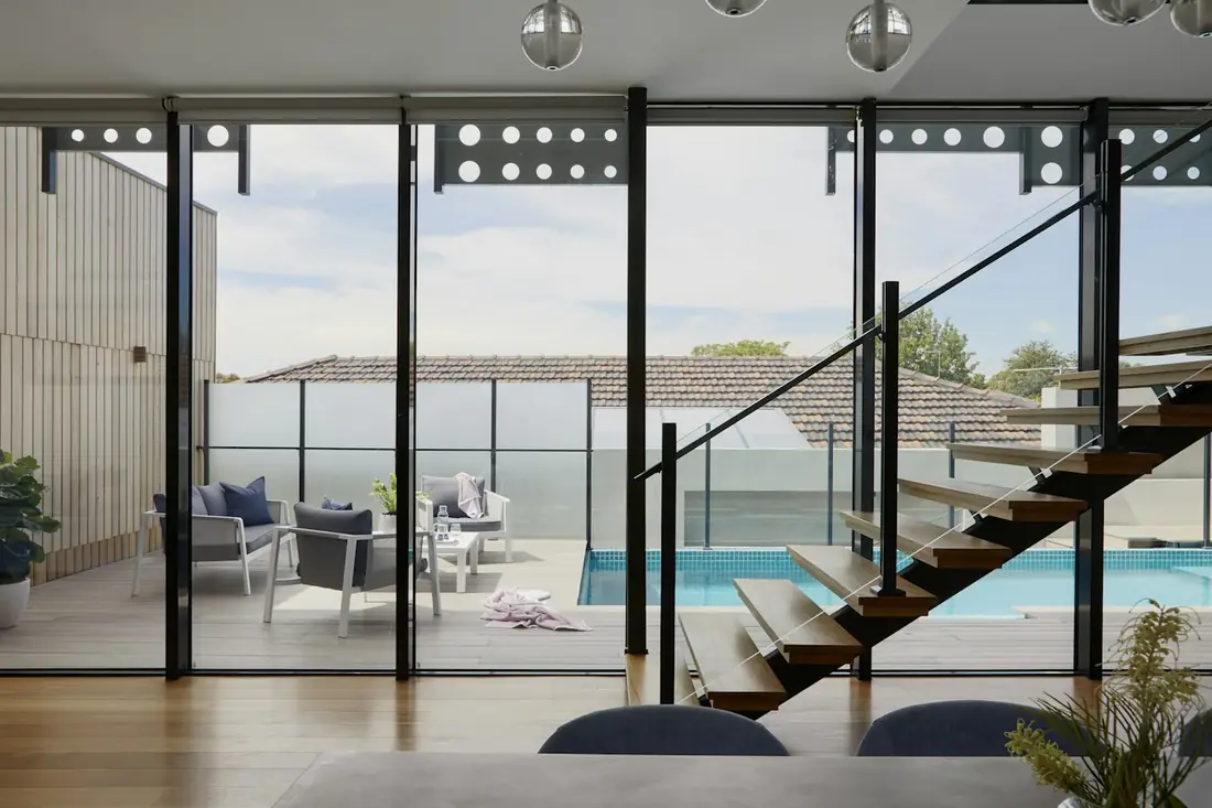 Interior com grandes panos de vidro abrindo para piscina