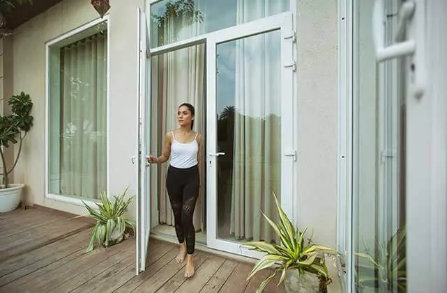 Porta de giro em PVC branco aberta para jardim